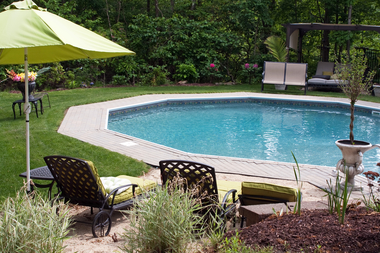 Detail view of a luxurious in ground pool and patio lounge this partly wooded backyard sbi 301048718
